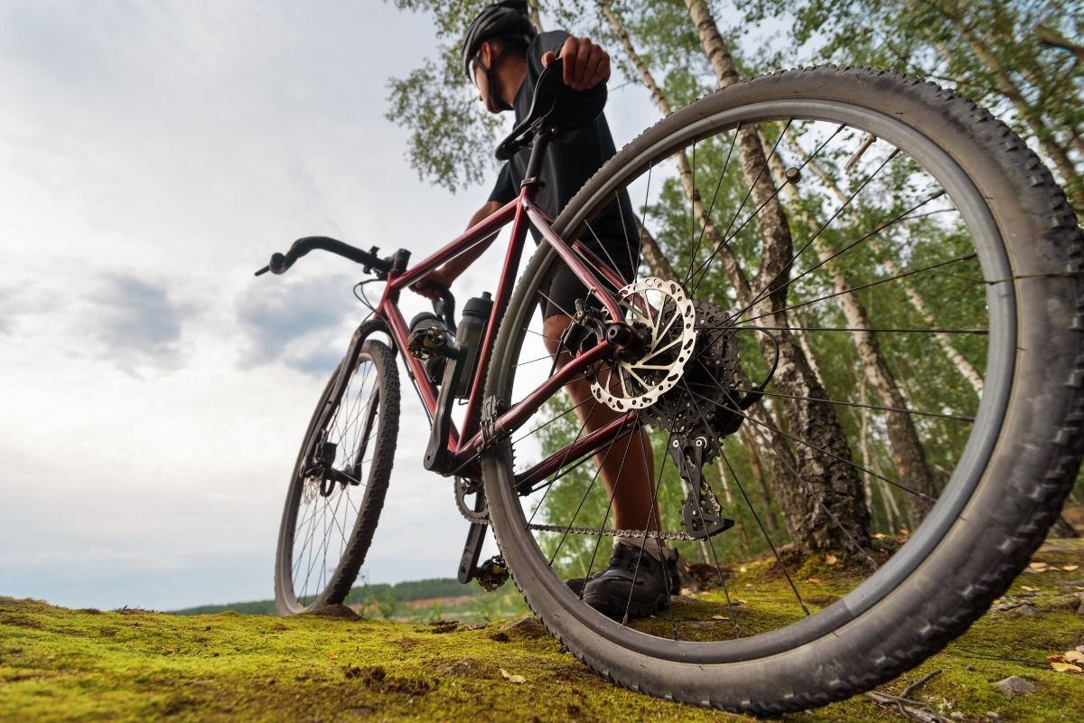 Xe Đạp Gravel Là Gì? Khác Gì Với Xe Road và MTB 2 Người đan ông đang dắt xe Gravel